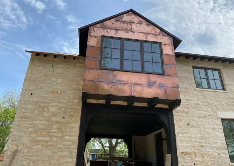 Copper metal panel facade on a stone building for Roof Repair in Beachwood